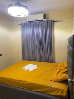 a bedroom with a yellow bed with a window at Lesnah Apartamento, Jacobo Majluta in Los Casabes