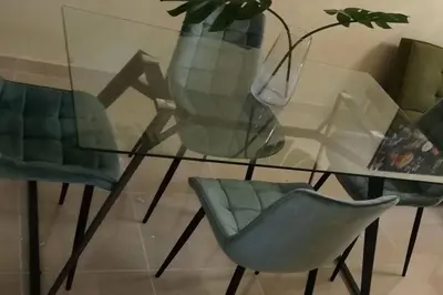 a glass table with two chairs and a vase at Lesnah Apartamento, Jacobo Majluta in Los Casabes