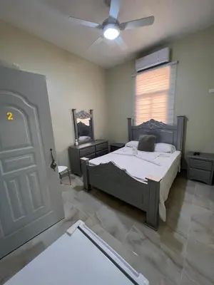 a bedroom with a bed and a window and a door at Hotel Unico in Santo Domingo