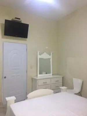 a bedroom with a white bed and a mirror at Hotel Unico in Santo Domingo
