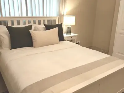 a bedroom with a large white bed with a window at Cómodo y Equipado Apt Cerca del Malecón in Santo Domingo