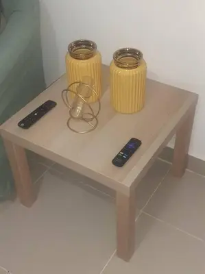 a wooden table with two remote controls on it at Comodas 3 Habitaciones, Wifi 1er piso in Santiago de los Caballeros