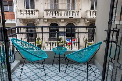 two blue chairs on a balcony with a building at Casa Adefra Boutique Hotel Zona Colonial in Santo Domingo