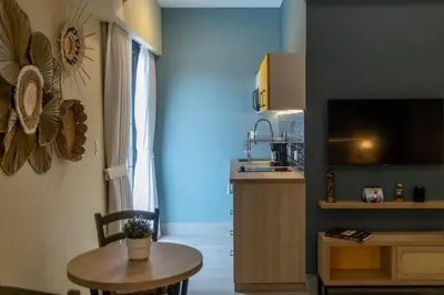 a living room with a table and a kitchen at Casa Adefra Boutique Hotel Zona Colonial in Santo Domingo