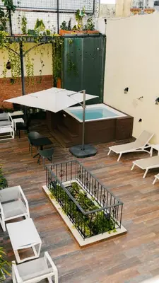 a patio with a table and chairs and a pool at Casa Adefra Boutique Hotel Zona Colonial in Santo Domingo