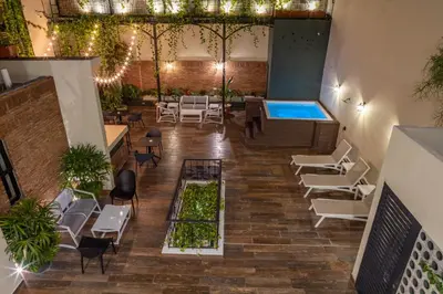 an indoor patio with a pool and tables and chairs at Casa Adefra Boutique Hotel Zona Colonial in Santo Domingo