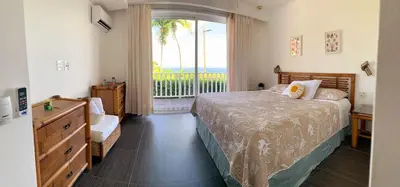 a bedroom with a bed and a large window at Perfect Paradise, Oceanview in Samana in Santa Bárbara de Samaná