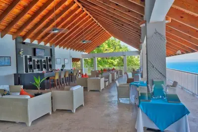 a restaurant with couches and tables and a bar at Perfect Paradise, Oceanview in Samana in Santa Bárbara de Samaná