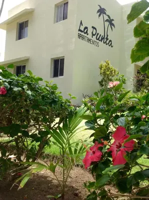 a view of a building with flowers in front of it at La Punta Apartamentos in Cabarete