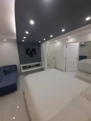 a white bedroom with a large bed and a tv at Hermoso apartamento Residencial madera I in Santiago de los Caballeros