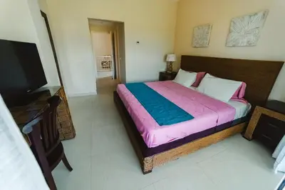 a bedroom with a bed and a flat screen tv at Private Villa LaPerla Iberosta 3BDR, Pool, Beach, WiFi in Punta Cana