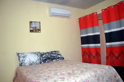 a bedroom with a bed and red curtains at Alojamiento Wilkenia in Ochoa