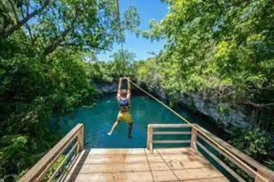a person jumping off a bridge into a river at Alojamiento Wilkenia in Ochoa