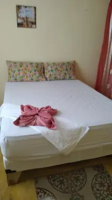 a white bed with a pink bow on it at Alojamiento Wilkenia in Ochoa
