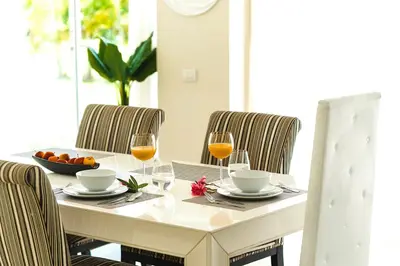 a table with two glasses of wine and a bowl of oranges at Private Iberosta Villa Fortuna - 4BDR, Pool & Private Beach in Punta Cana
