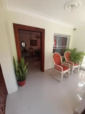 a living room with two chairs and a table at Hermosa casa urbanización Jardines del Norte in Santiago de los Caballeros