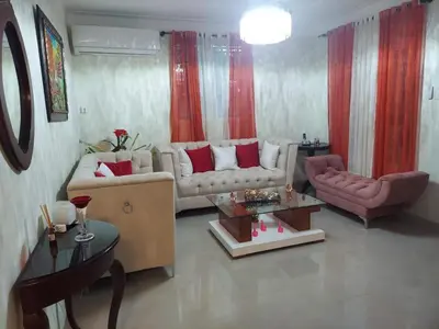 a living room with two couches and a table at Hermosa casa urbanización Jardines del Norte in Santiago de los Caballeros