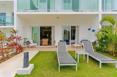 a house with two chairs and a courtyard at Cana Rock Condos Familiar - Two apartments very close-Ground floor direct access to the pool in Punta Cana