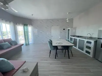 a kitchen and living room with a table and chairs at Apartamentos La Torre in Río San Juan