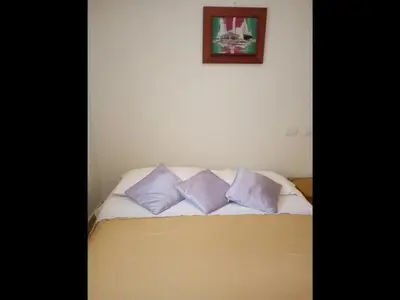 a bed with three purple pillows in a room at Delightful Caribbean apartment in Boca Chica in Boca Chica