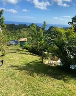 a garden with a view of the ocean at Tropical Cottage En Eco Casa Algana in El Limón