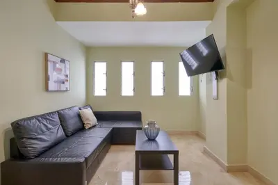 a living room with a couch and a tv at Escape 3BR Apartment in the Heart of Piantini Nightlife in Santo Domingo