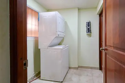 a white refrigerator in a room with a door at Escape 3BR Apartment in the Heart of Piantini Nightlife in Santo Domingo