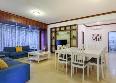 a living room with a table and a blue couch at Escape 3BR Apartment in the Heart of Piantini Nightlife in Santo Domingo