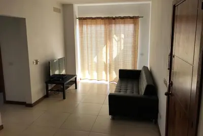 a living room with a couch and a table and a window at Maggy's House in La Romana