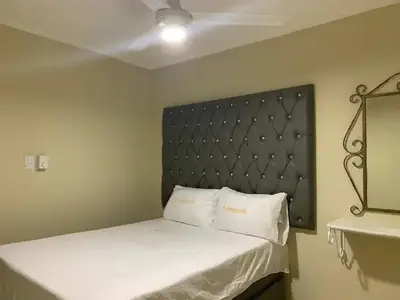 a bedroom with a bed with a black headboard at Glamour Hotel in La Romana