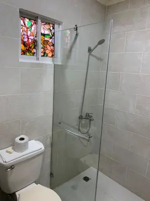 a bathroom with a shower with a toilet and a window at Glamour Hotel in La Romana