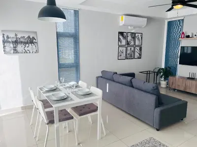a living room with a couch and a table and a tv at Townhouse with Private Pool and nearby beaches in Punta Cana