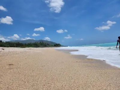 a person standing on a beach near the ocean at Beachfront Apartment, Quiet 4 Beds, 1 Bath, AC, Wi-Fi, Hot Water, in Paraiso near Los Patos in Paraíso
