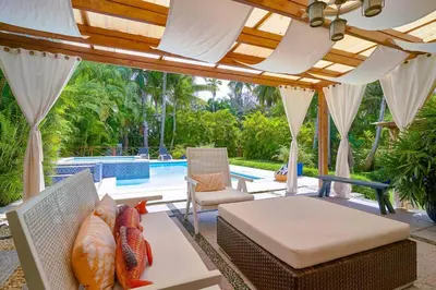 a patio with a couch and a table and a pool at Escape Beach Villa in El Portillo, Las Terrenas in Las Terrenas