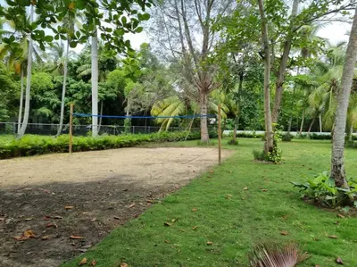 a volleyball court in a park with trees at Escape Beach Villa in El Portillo, Las Terrenas in Las Terrenas