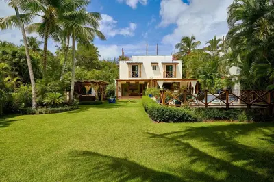 a house with a large yard with grass and palm trees at Escape Beach Villa in El Portillo, Las Terrenas in Las Terrenas