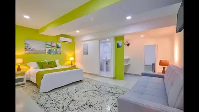 a bedroom with a bed and a living room with a couch at Malecon Premium Plus in Santo Domingo