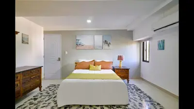 a bedroom with a large bed and a dresser at Malecon Premium Plus in Santo Domingo