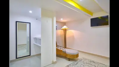 a bathroom with a bench and a large mirror at Malecon Premium Plus in Santo Domingo