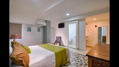 a bedroom with a bed and a desk and a chair at Malecon Premium Plus in Santo Domingo