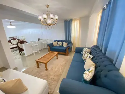a living room with a blue couch and a table at Dr Adorable Y Comfortable Apt para Su Disfrute in Santiago de los Caballeros