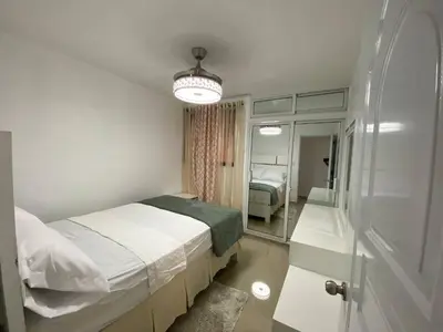 a small bedroom with a bed and a mirror at Dr Adorable Y Comfortable Apt para Su Disfrute in Santiago de los Caballeros