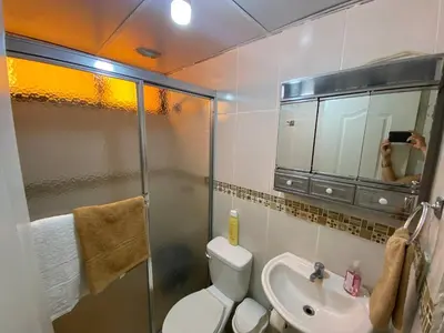 a person taking a picture of a bathroom with a toilet and sink at Dr Adorable Y Comfortable Apt para Su Disfrute in Santiago de los Caballeros