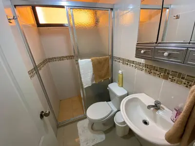 a bathroom with a shower and a toilet and a sink at Dr Adorable Y Comfortable Apt para Su Disfrute in Santiago de los Caballeros