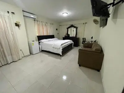 a bedroom with a bed and a couch in it at Maria's Entire House HIGUEY 2BD in Higuey