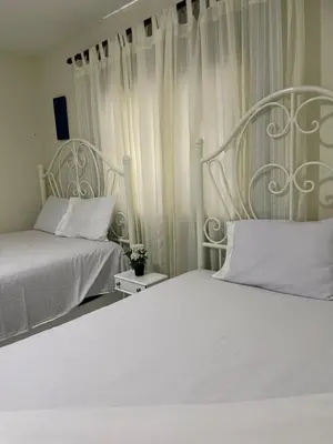 two beds sitting next to each other in a bedroom at Maria's Entire House HIGUEY 2BD in Higuey