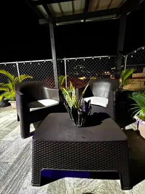 a table and chairs on a patio with a table and flowers at Lovely tiny studio in Jarabacoa