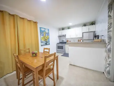 a small kitchen with a wooden table and chairs at Stylish 1r-1b Apt Near The Beach And Main Street in Sosúa