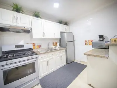 a kitchen with white cabinets and white appliances at Stylish 1r-1b Apt Near The Beach And Main Street in Sosúa