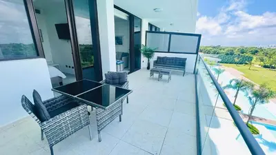 a balcony of a house with a table and chairs at Luxury Apartment With Pool And Golf View in Punta Cana